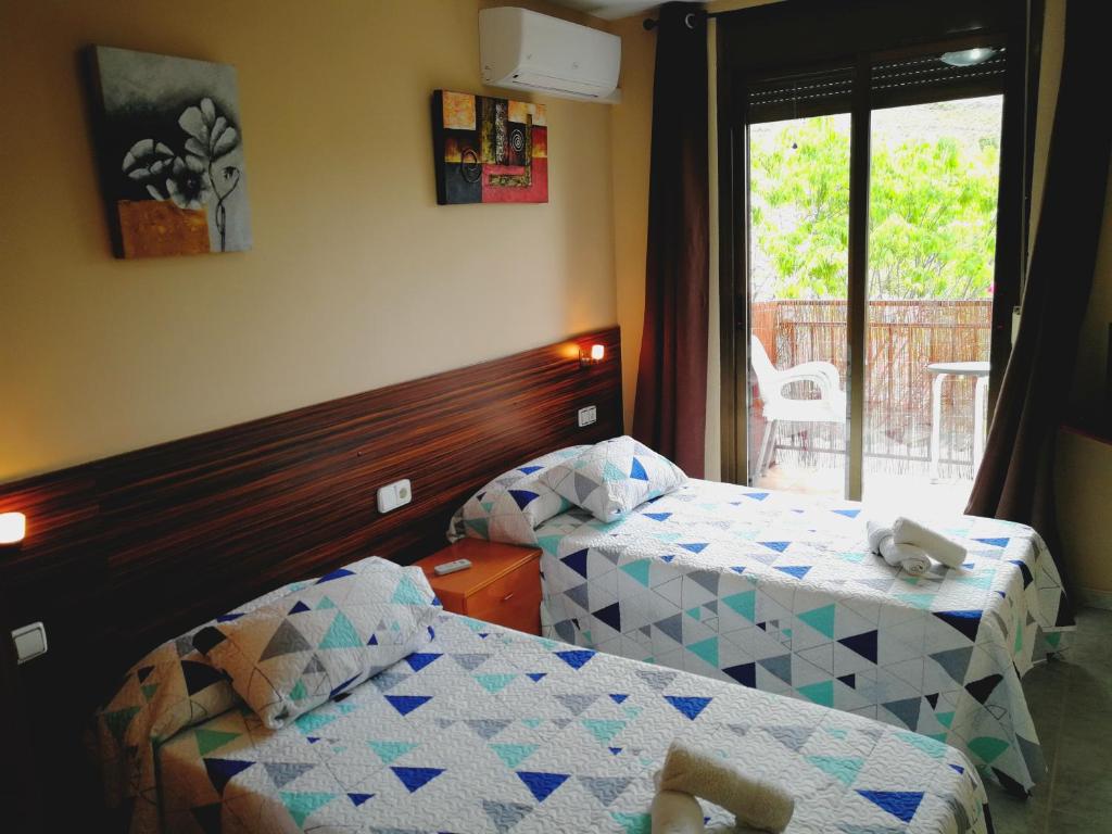 una camera d'albergo con due letti e una finestra di Hostal Escarla ad Arén