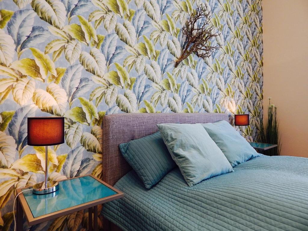 - une chambre avec un lit et un papier peint floral dans l'établissement Hello Downtown Apartment - Broadway, à Budapest