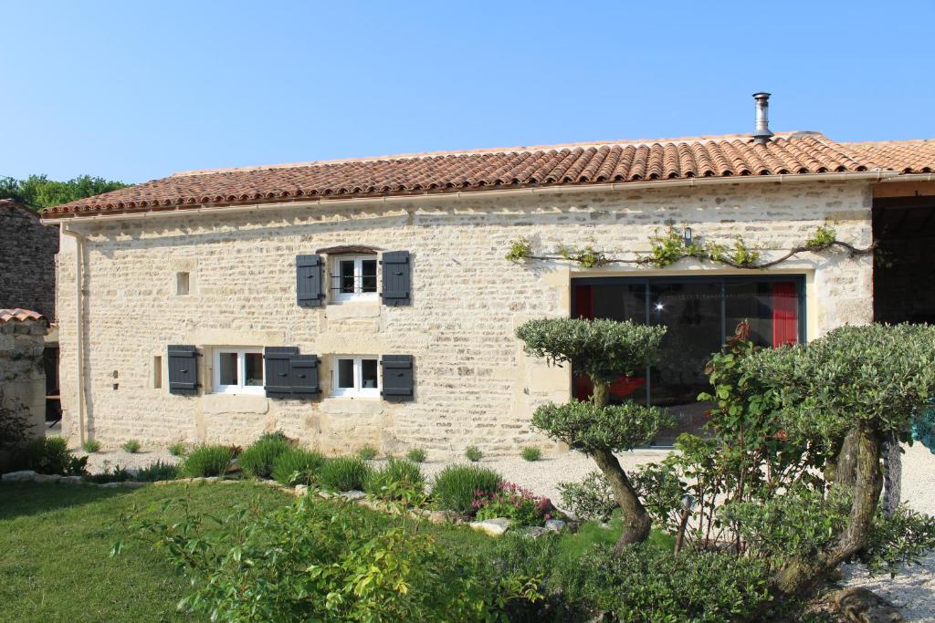 una casa de piedra con un jardín delante de ella en gite les rouets, en Hanc