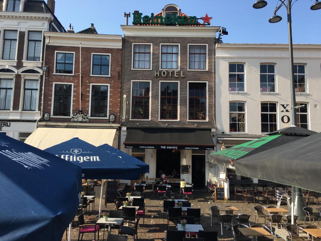 un hotel con mesas y sillas frente a un edificio en Amadeus Hotel, en Haarlem