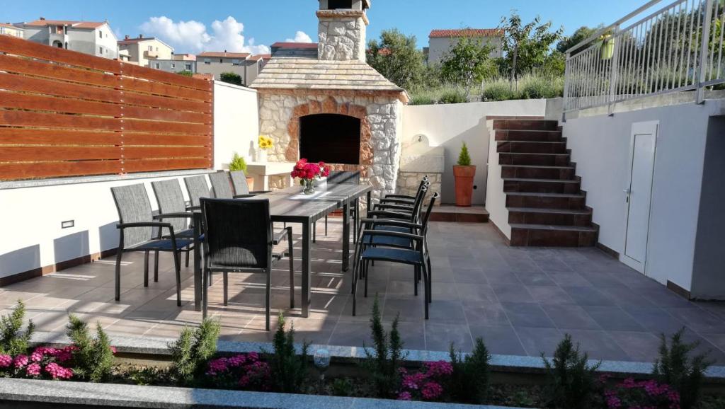 eine Terrasse mit Stühlen, einem Tisch und einem Steinkamin in der Unterkunft Apartment Split4me in Split