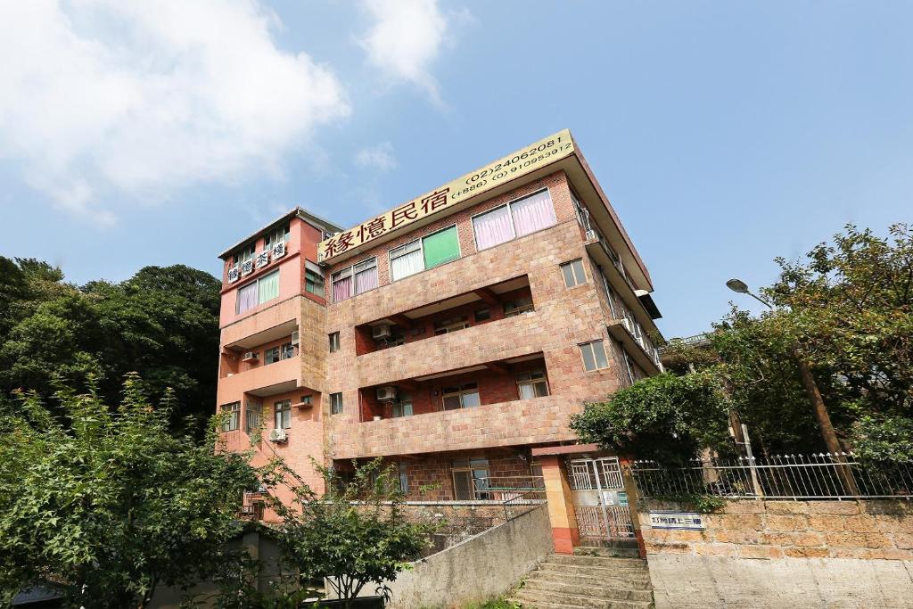 wysoki ceglany budynek z napisem w obiekcie Yuan-Yee Homestay w mieście Jiufen