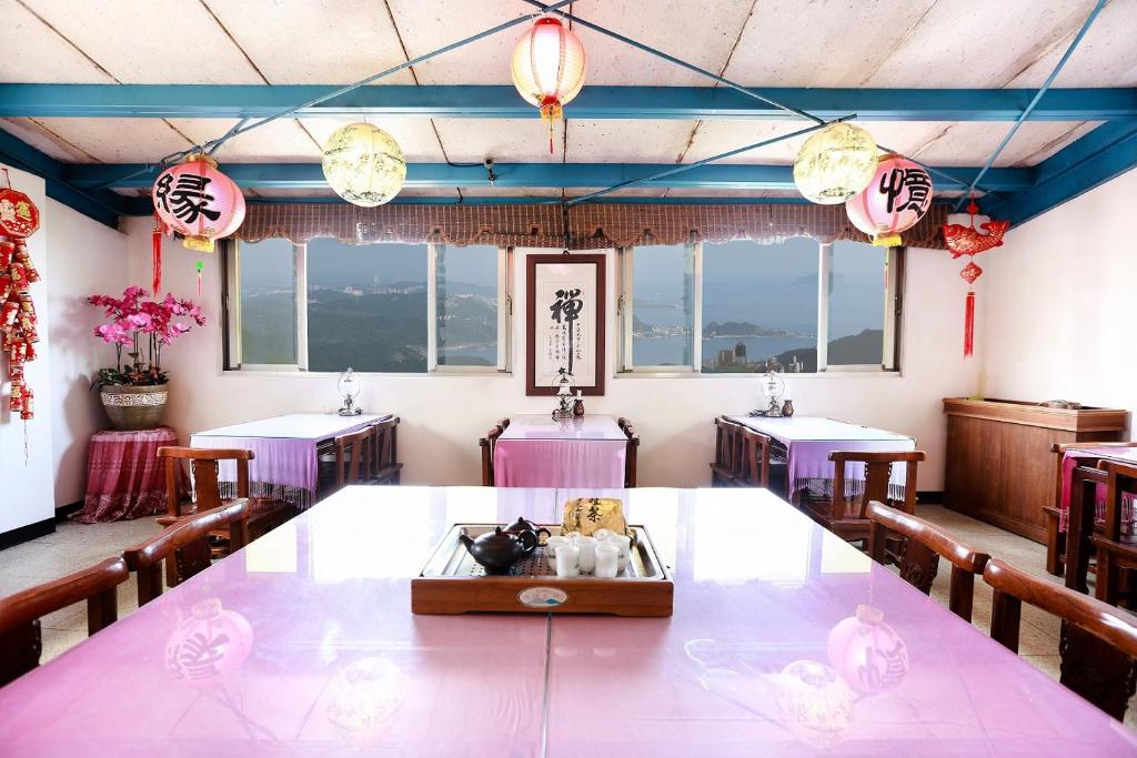 a dining room with tables and chairs and lights at Yuan-Yee Homestay in Jiufen