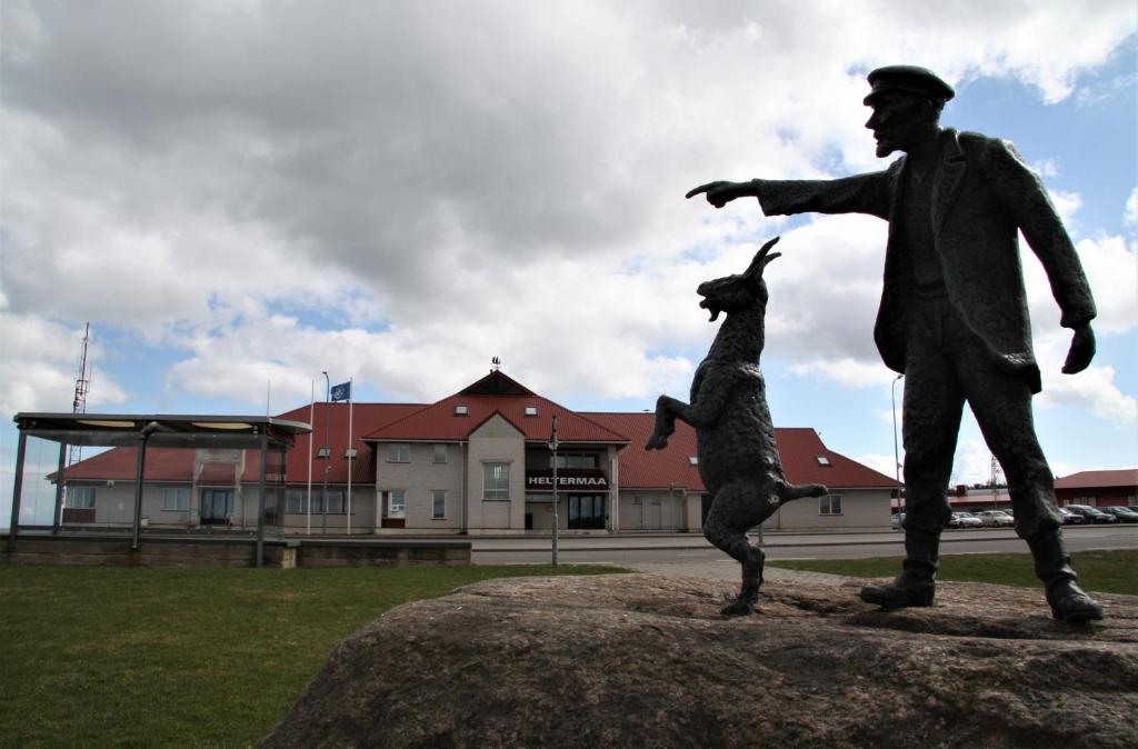 Heltermaa Hostel في Heltermaa: تمثال رجل وكلب على صخرة