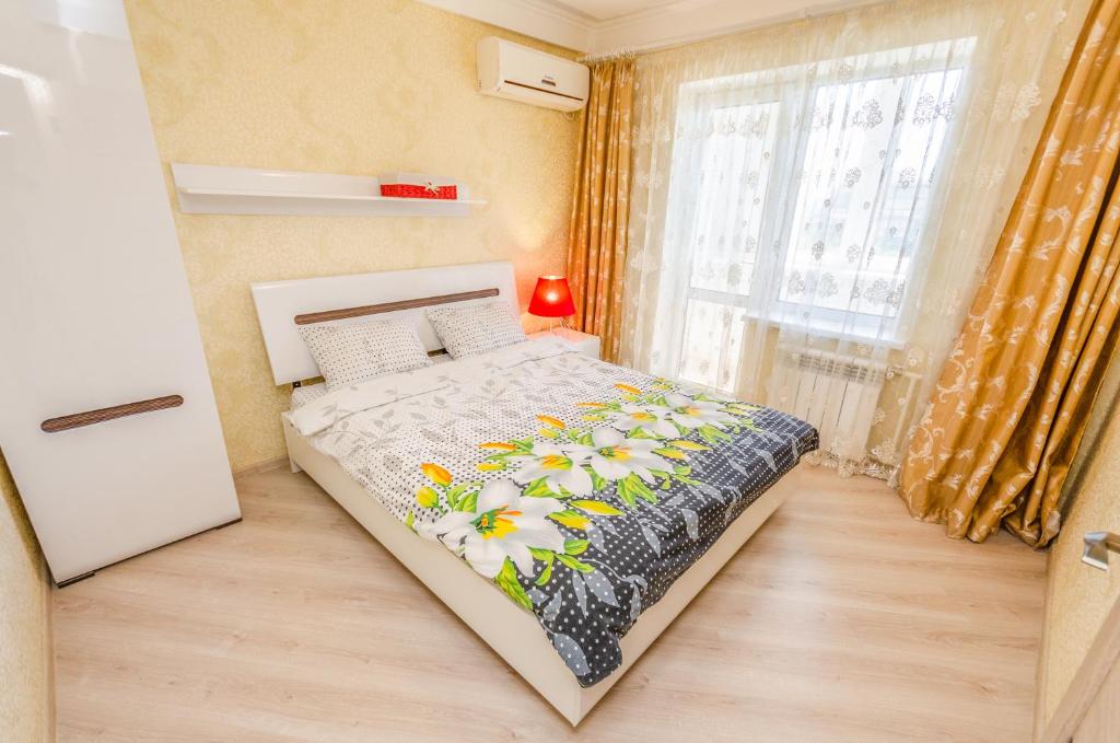 a small bedroom with a bed with flowers on it at ARTAL Apartment on Obolonskyi Avenue 16a in Kyiv