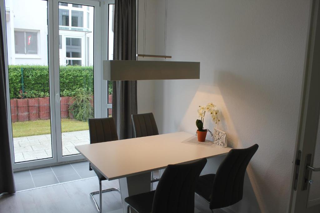 a dining room with a table and chairs and a window at 29 Strandstraße, Wohnung 2 in Baabe