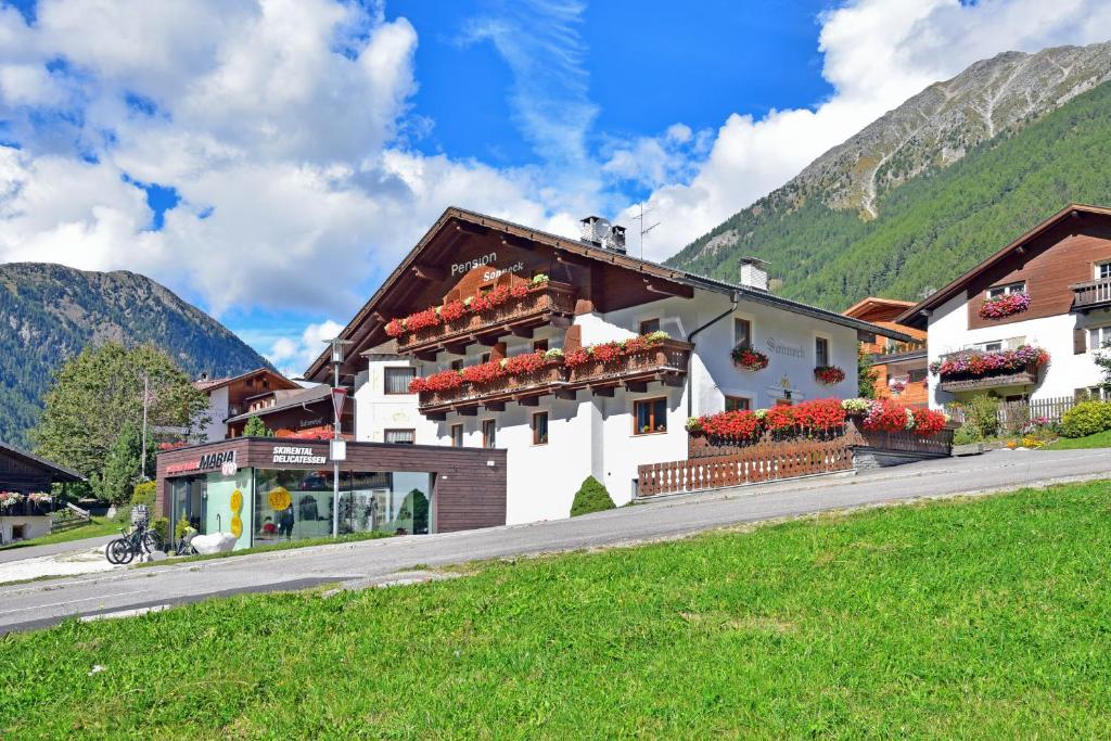 un bâtiment avec des boîtes de fleurs sur son côté dans l'établissement Pension SONNECK, à Valles