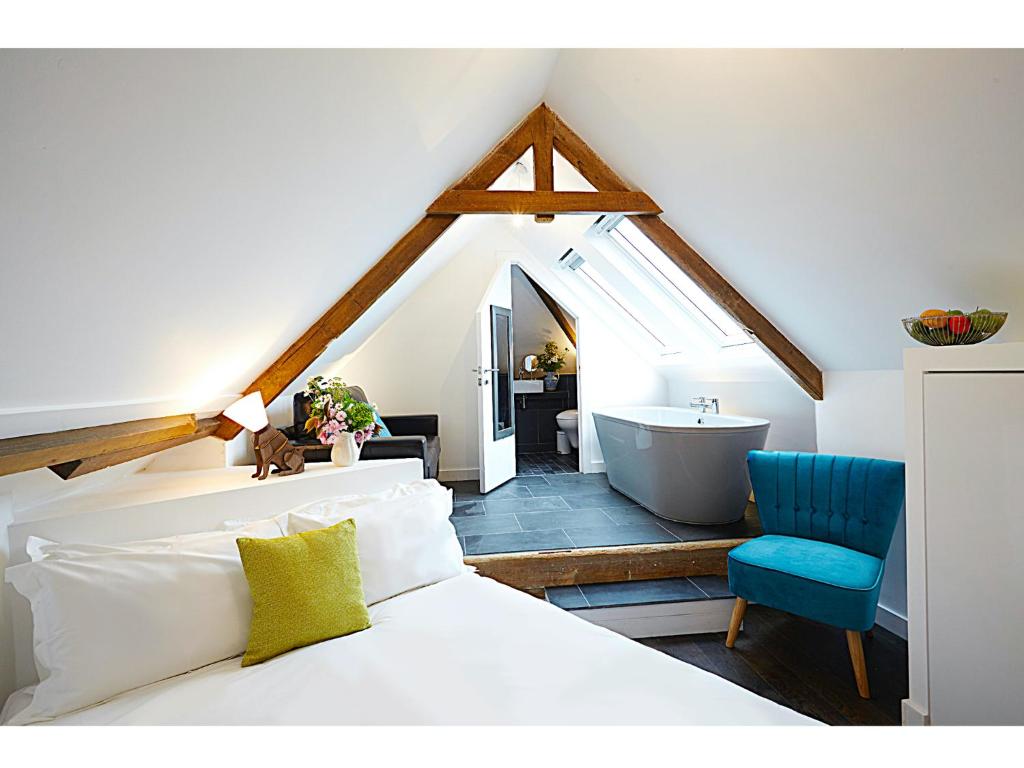 um quarto com uma cama e uma casa de banho com uma banheira em Live & Let Live Inn em Woodland