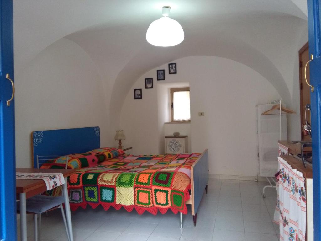 a bedroom with a bed and a table and a window at Casetta Blu in Tricarico