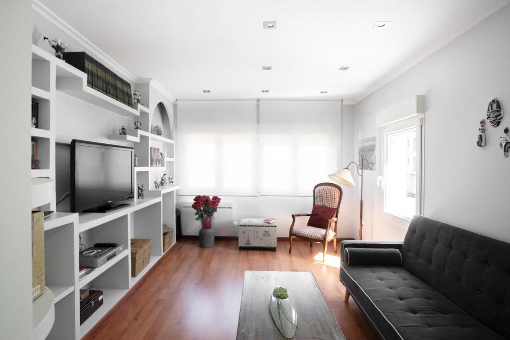 a living room with a couch and a tv at Vivienda O Pombal in Cambados