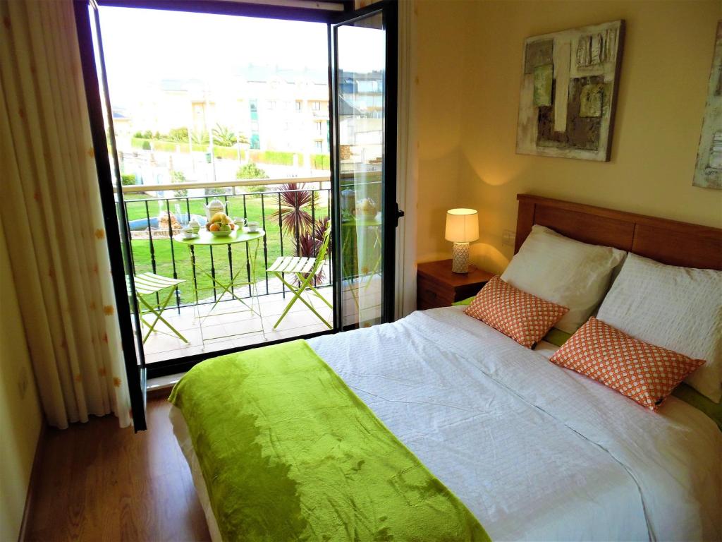 1 dormitorio con 1 cama y balcón con vistas. en Playa de Altar Barreiros, en Villadaíde