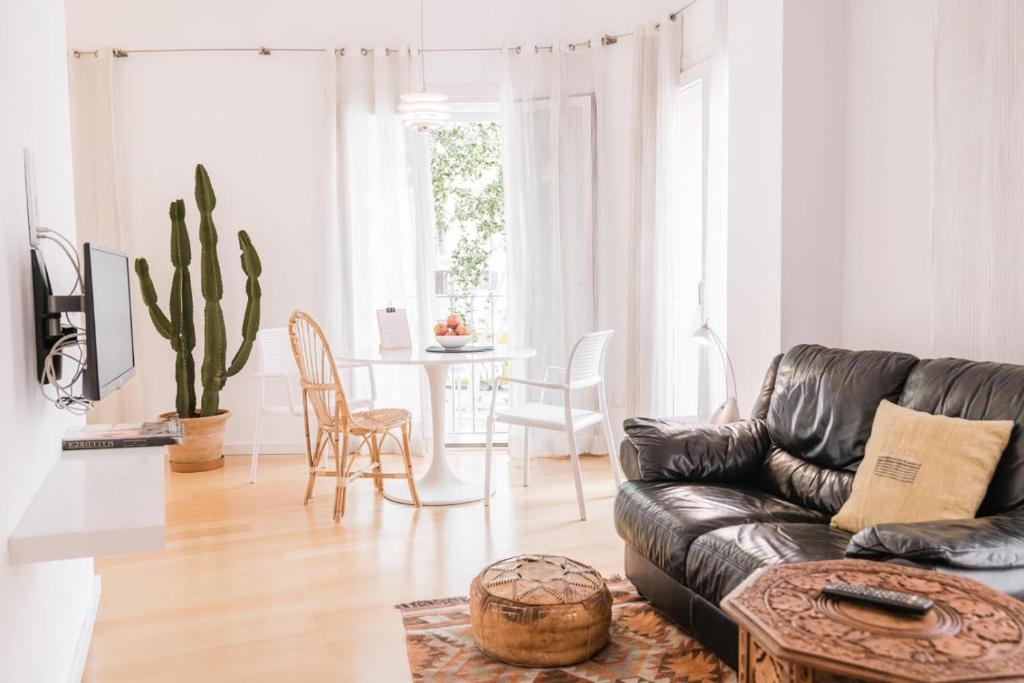 a living room with a black leather couch and a table at Montmari - Turismo de Interior in Palma de Mallorca