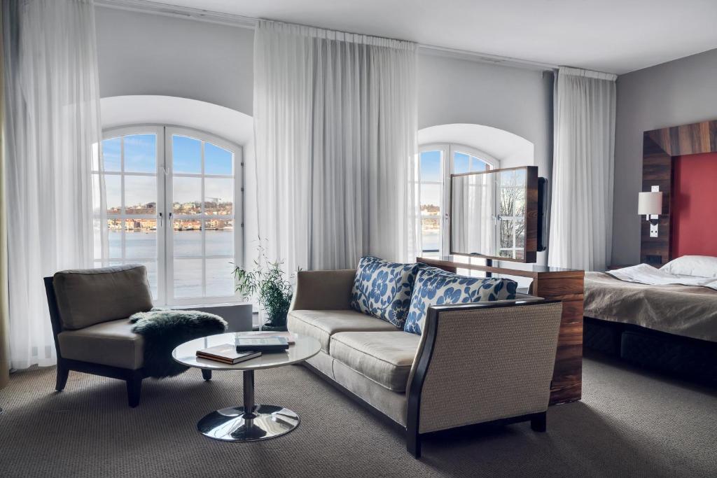 uma sala de estar com um sofá e uma cama em Elite Hotel Marina Tower, Spa & Resort em Estocolmo