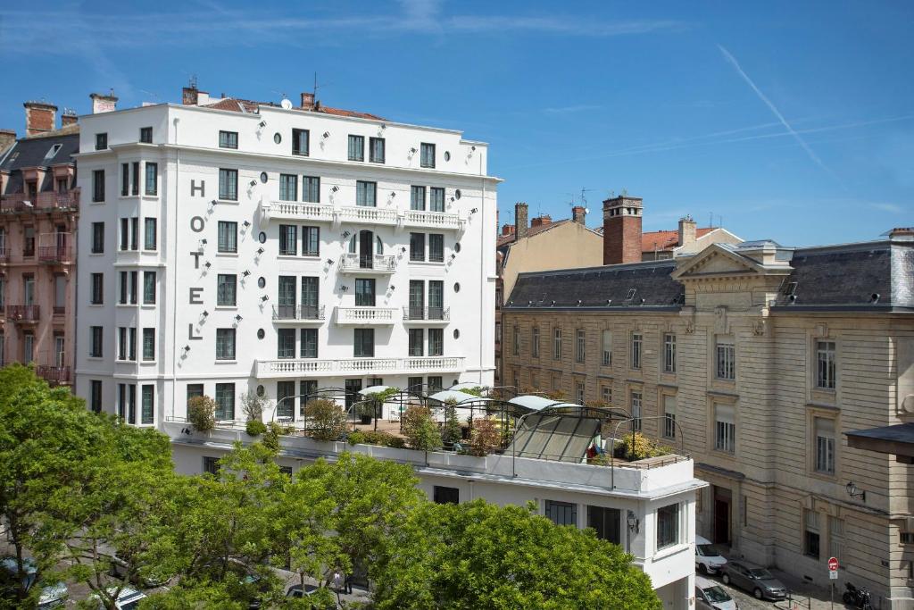 ein weißes Gebäude in der Mitte einiger Gebäude in der Unterkunft Collège Hôtel in Lyon