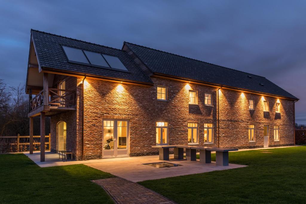 a large brick building with lights on it at B&B De Windheer in Sint-Martens-Lennik