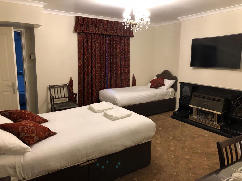 a hotel room with two beds and a fireplace at Albany Hotel in London