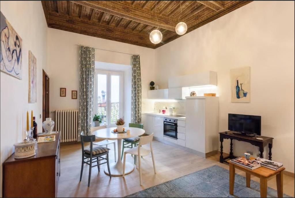 Il comprend une cuisine et un salon avec une table et des chaises. dans l'établissement Appartamento in Palazzo Bucelli, à Montepulciano