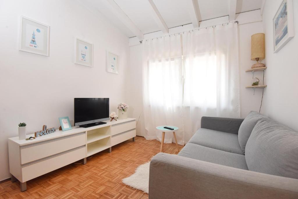 a living room with a couch and a tv at Sun and sea apartment in Zadar