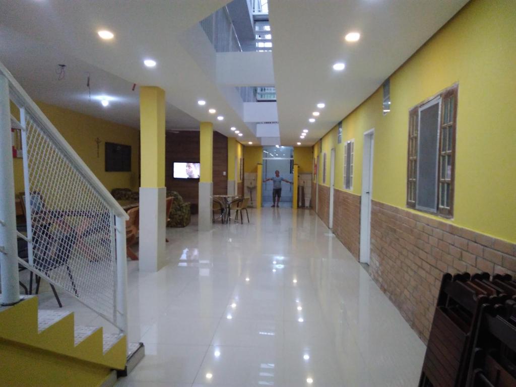 a hallway of a building with a person walking down it at Pousada Casa Verde in Aparecida