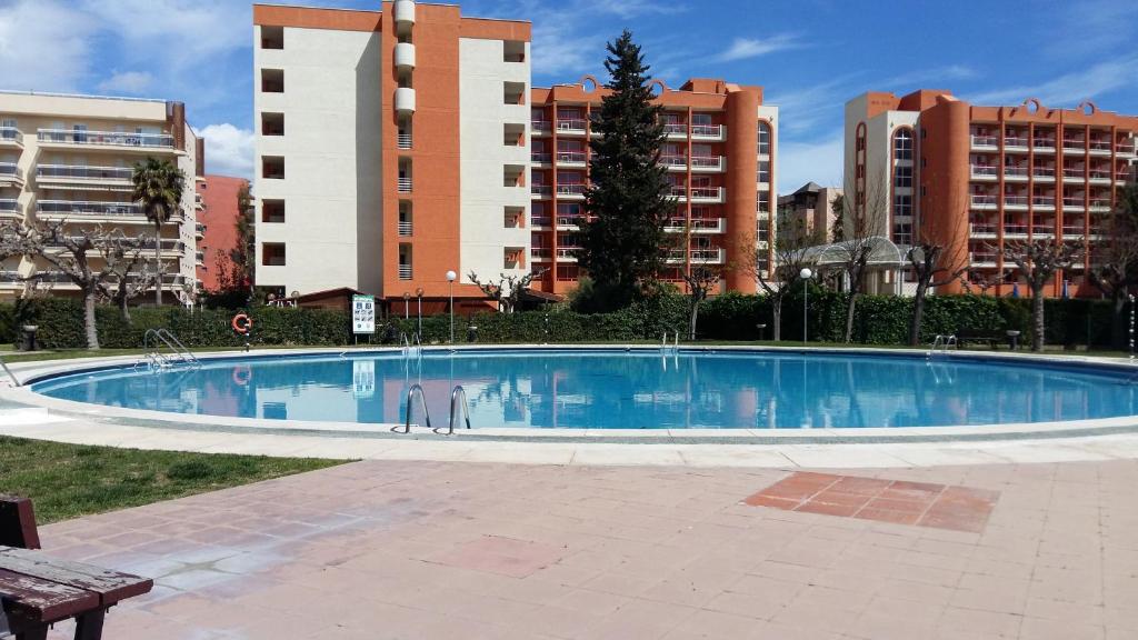 une grande piscine avec des bâtiments en arrière-plan dans l'établissement Bonito Apartamento con varias piscinas, à Salou