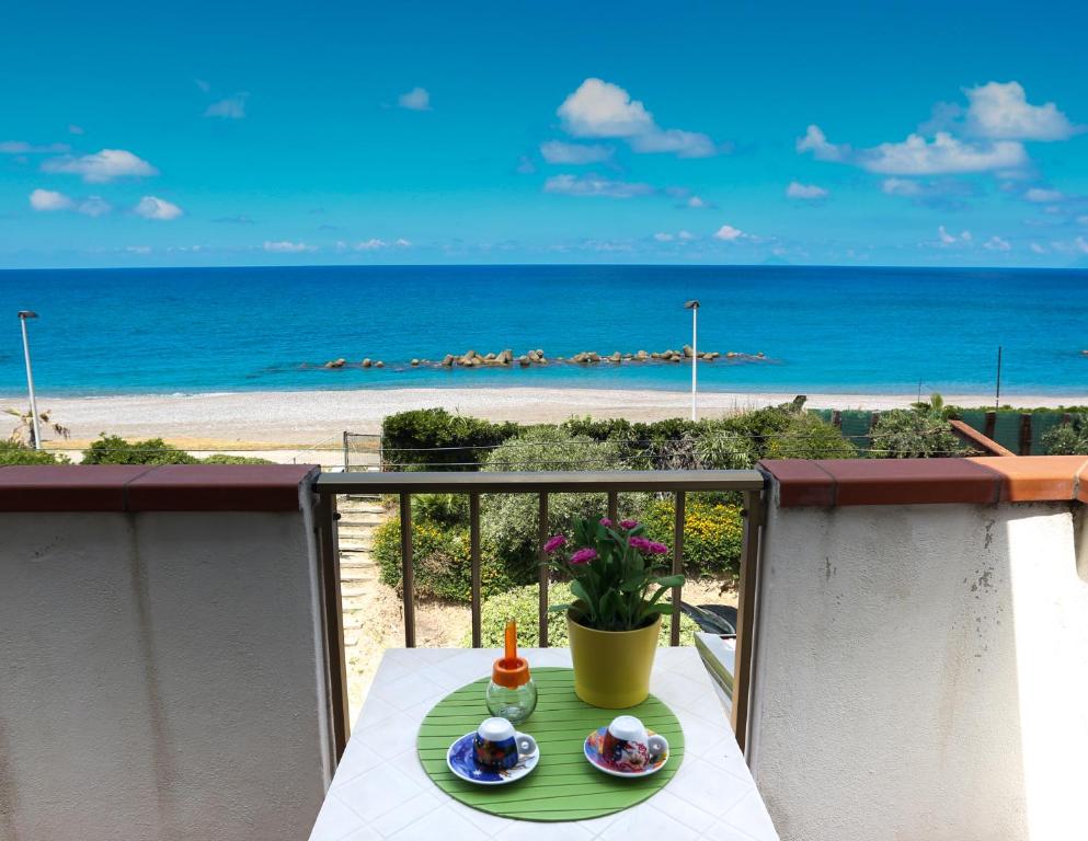 einen Tisch auf dem Balkon mit Blick auf den Strand in der Unterkunft Sapore di Mare in Capo dʼOrlando