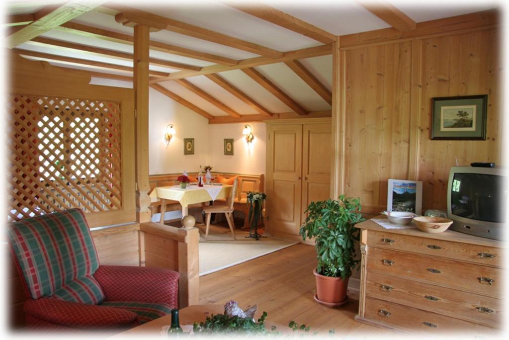 ein Wohnzimmer mit einem TV und einem Esstisch in der Unterkunft Ferienapartment Haus Raith in Kreuth