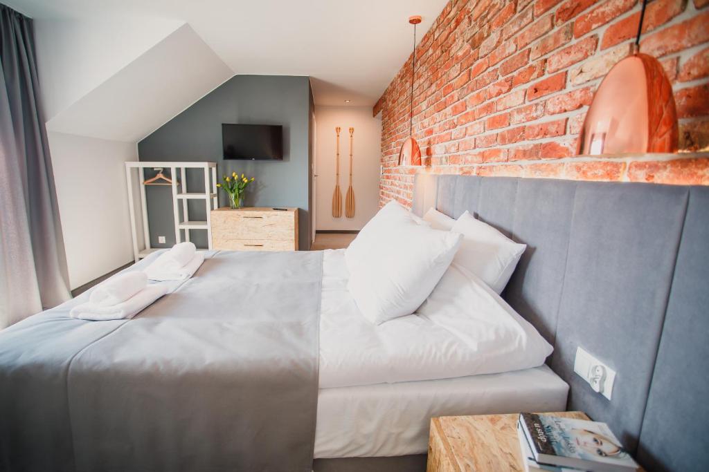 a bedroom with a bed and a brick wall at Łososiowa 3 in Jarosławiec