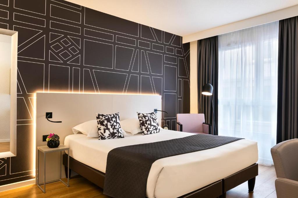 - une chambre avec un lit et un mur noir dans l'établissement Citadines Kléber Strasbourg, à Strasbourg