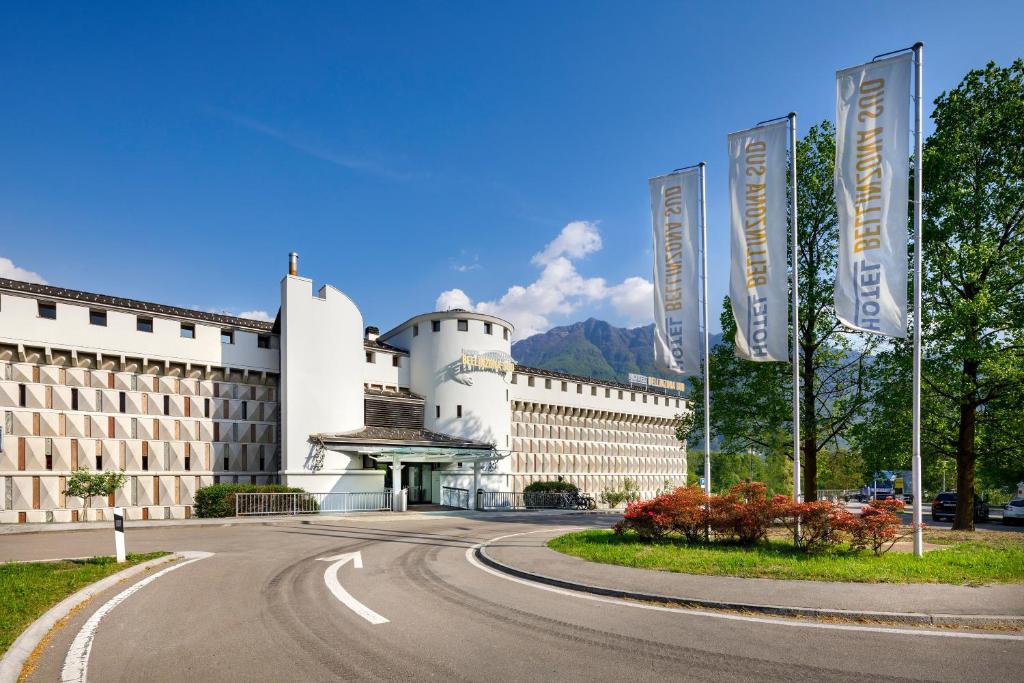 um edifício com uma estrada curva à sua frente em Hotel Bellinzona Sud Swiss Quality em Monte Carasso