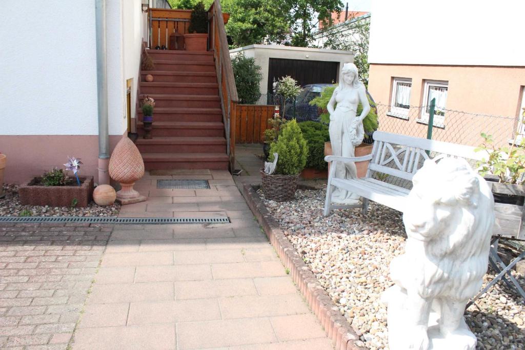 a patio with a bench and some statues in front of a house at Ferienwohnung Stadtidyll in Michelstadt