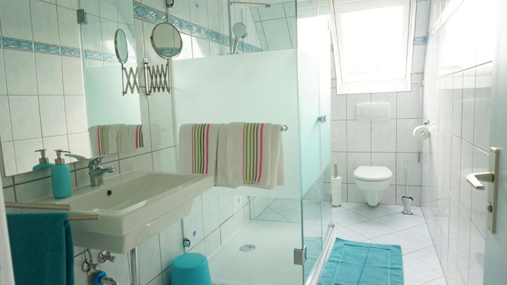 a white bathroom with a sink and a toilet at Ferien-Whg Stünkel nähe Steinhuder Meer in Steinhude