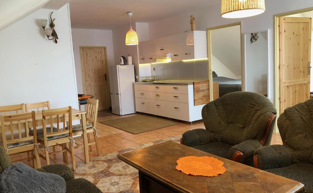 uma sala de estar com uma cozinha e uma mesa e cadeiras em Apartament Pod Kasztanami - ZIELONY em Ińsko