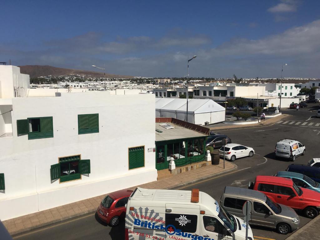 a parking lot with cars parked in front of a building at Casa salzano in Playa Blanca