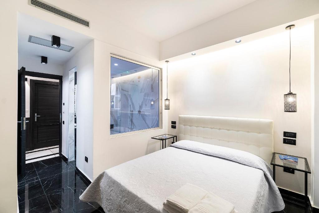 Habitación blanca con cama y ventana en Chez Anna B&B - Adults only en Nápoles