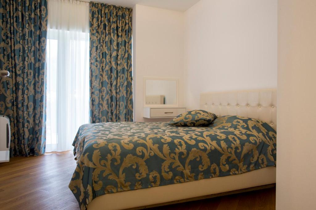 una camera con letto e finestra con tende di Apartman Anna Tre Canne Budva a Budua