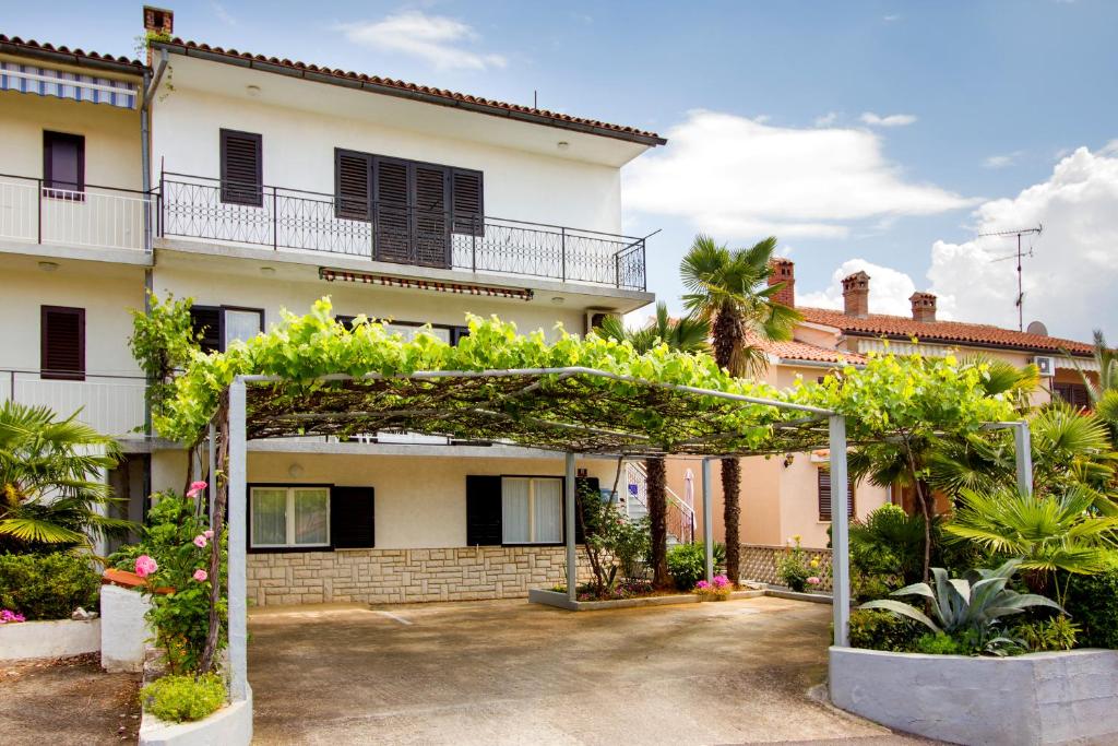 una casa con un arco delante de ella en Apartment Brle, en Poreč