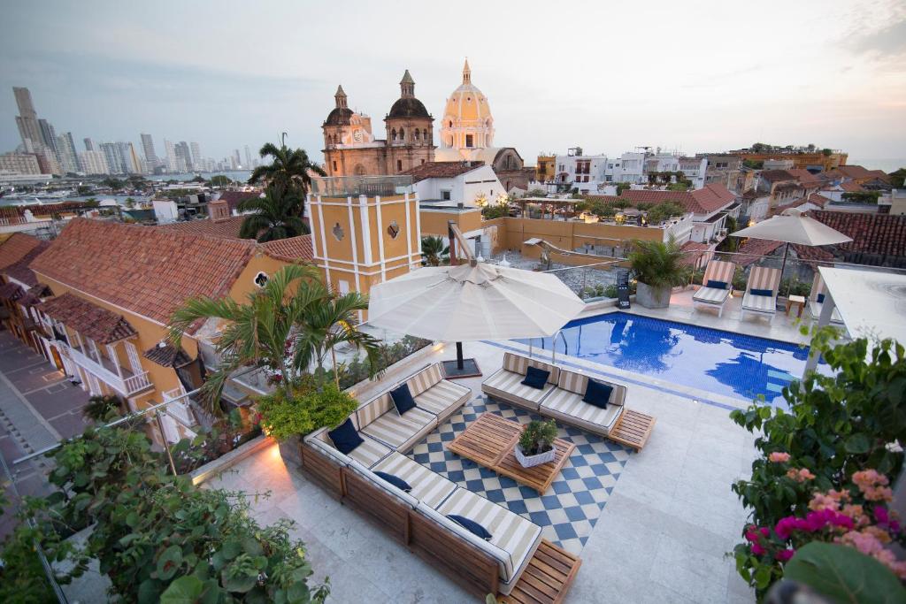 una piscina con sillas y una sombrilla en la parte superior de un edificio en Sophia Hotel, en Cartagena de Indias