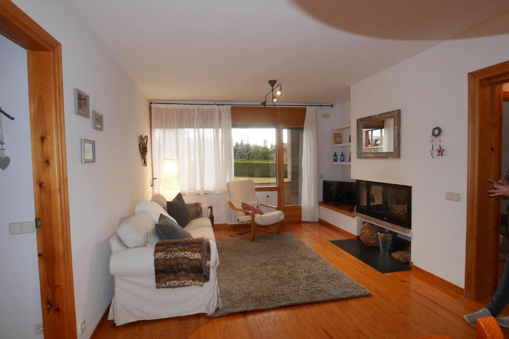 sala de estar con sofá blanco y chimenea en Cozy Apartment in Alp, en Alp