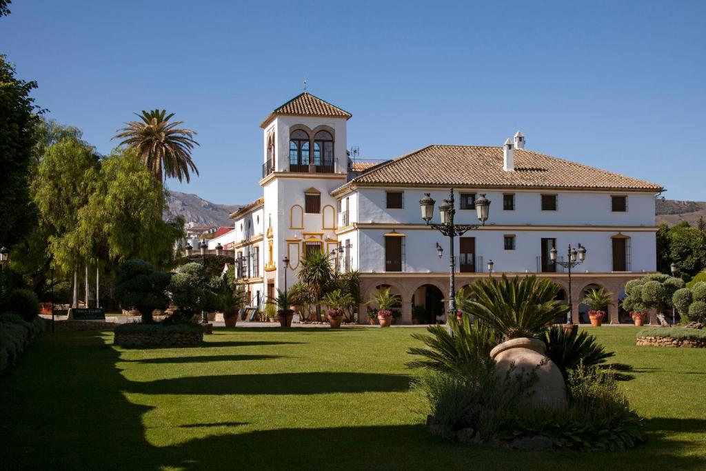 un gran edificio blanco con una torre de reloj en Finca Eslava en Antequera