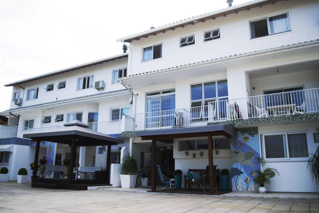 a large white building with balconies and a patio at Pousada Kindermann in Florianópolis