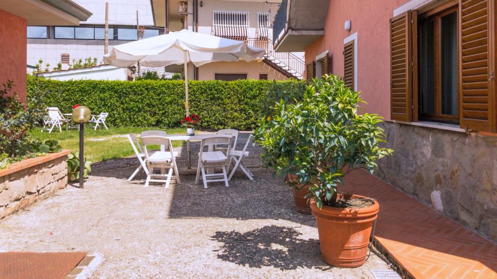 a patio with a table and chairs and an umbrella at Charme Montecatini Villa in Pieve a Nievole