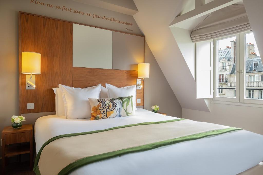 - une chambre avec un grand lit blanc et une fenêtre dans l'établissement Hôtel Le Tourville by Inwood Hotels, à Paris