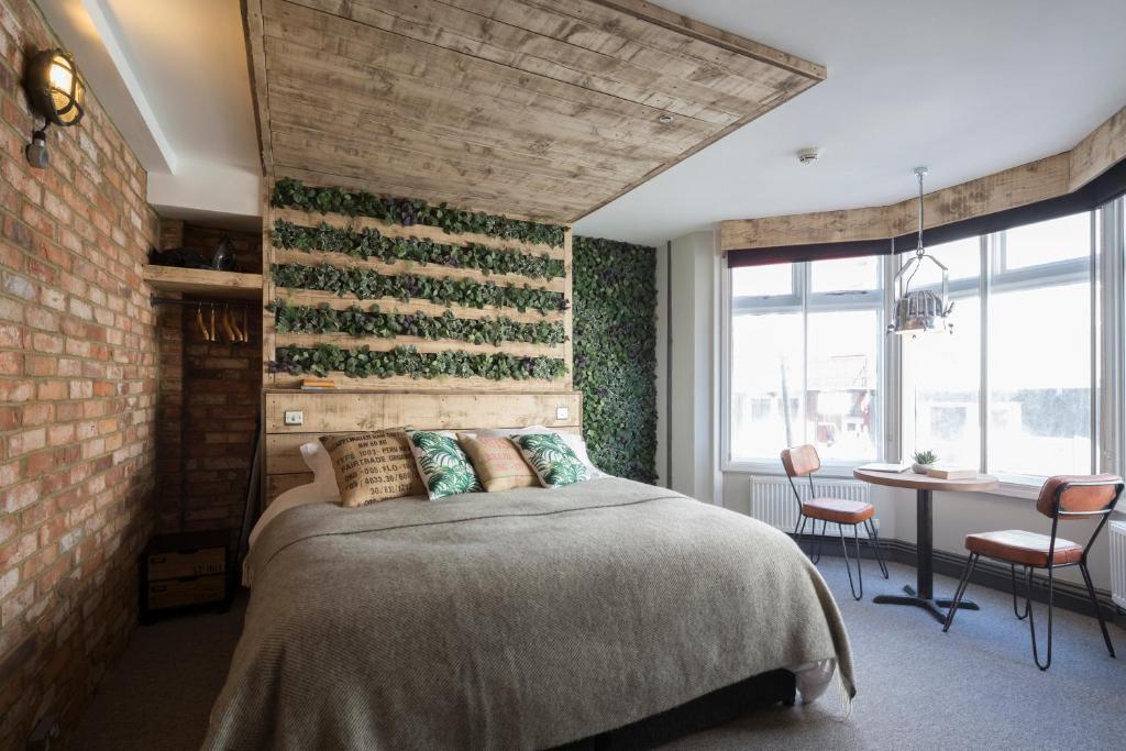 a bedroom with a bed and a brick wall at One Broad Street in Brighton & Hove