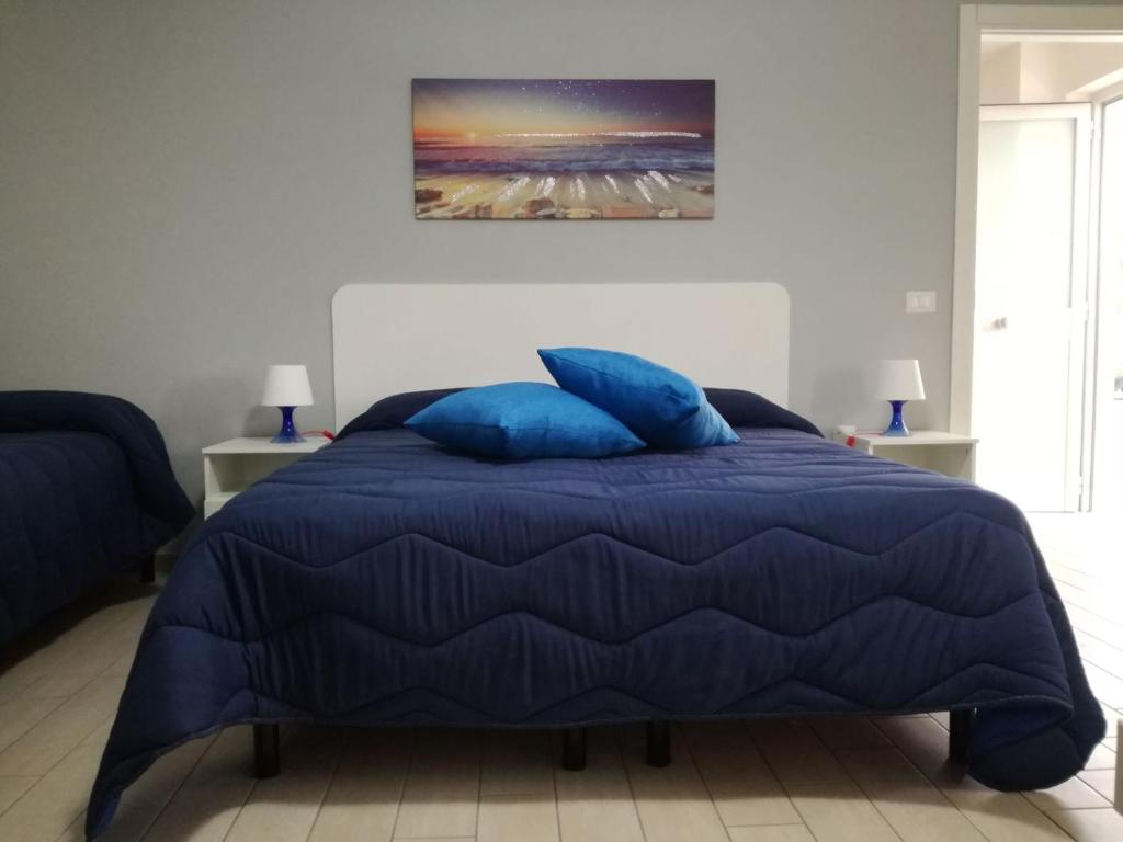 uma cama azul com almofadas azuis num quarto em B&B dal Gallo em Battipaglia