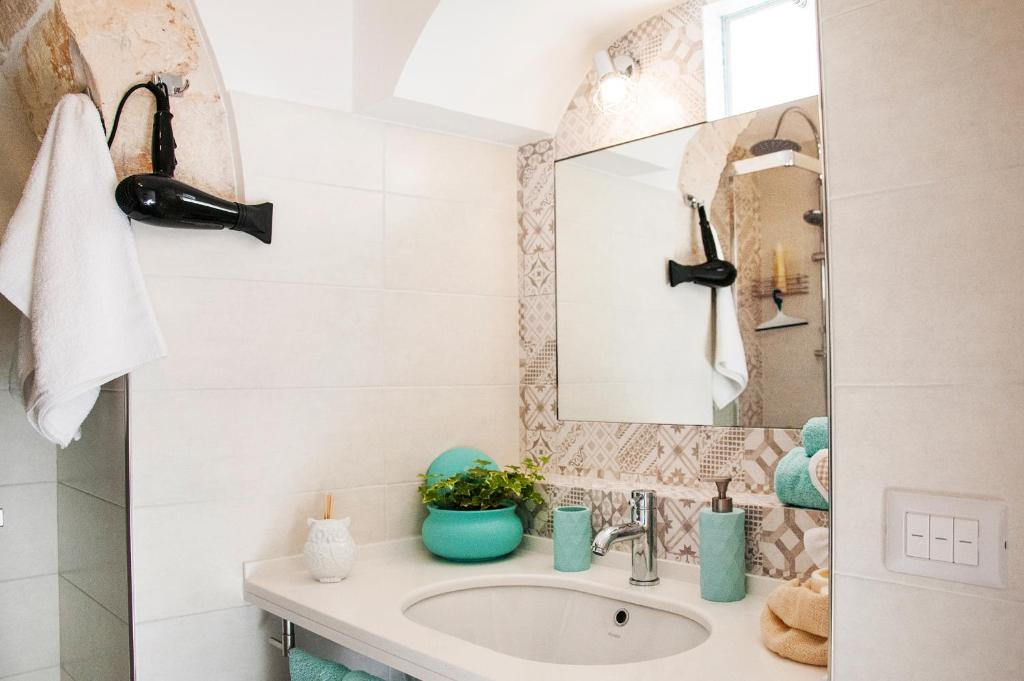 a bathroom with a sink and a mirror at Iannet & Co. in Locorotondo