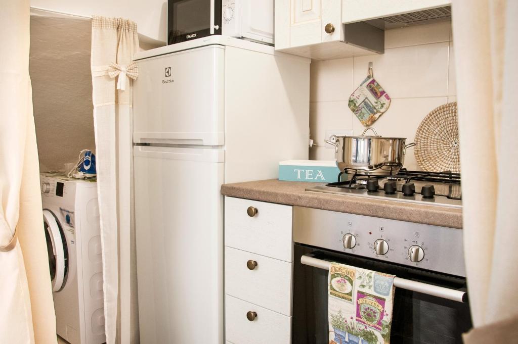 a small kitchen with a refrigerator and a stove at Iannet & Co. in Locorotondo