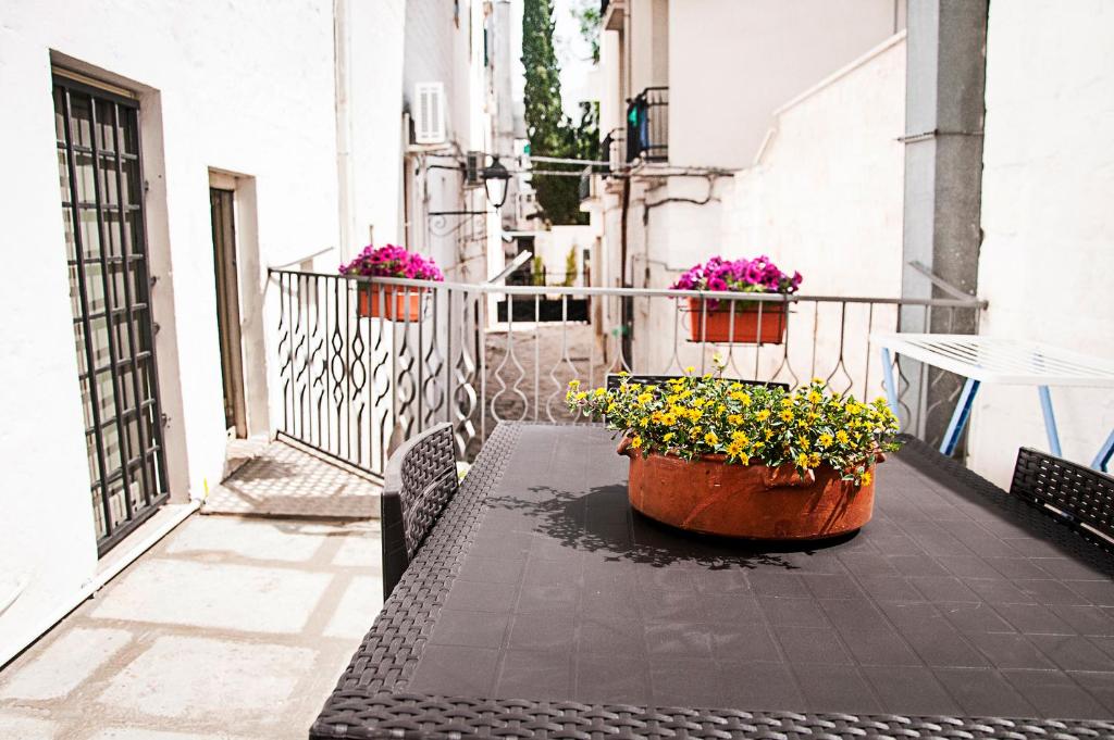 a table with two pots of flowers on a balcony at Iannet & Co. in Locorotondo