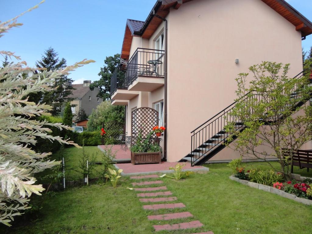 a house with a garden in front of it at Pokoje Gościnne u Teresy in Mrzeżyno