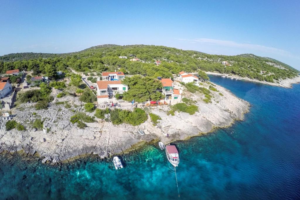 uma ilha com casas e barcos na água em Poseidon Holiday Guesthouse em Žirje