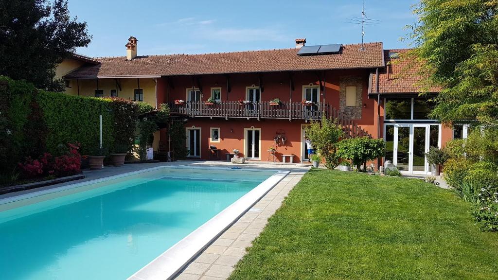 ein Haus mit einem Pool vor einem Haus in der Unterkunft B&B La Cascina di Monia e Mario in Borgo Ticino